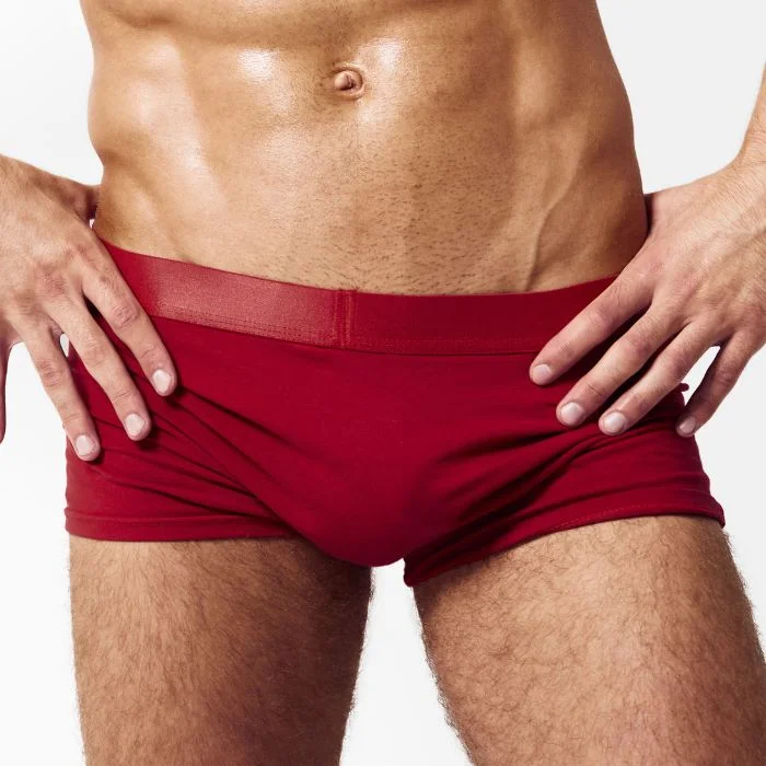 Άνδρας με κόκκινα, εφαρμοστά sexy ανδρικά εσώρουχα, σε λευκό φόντο.