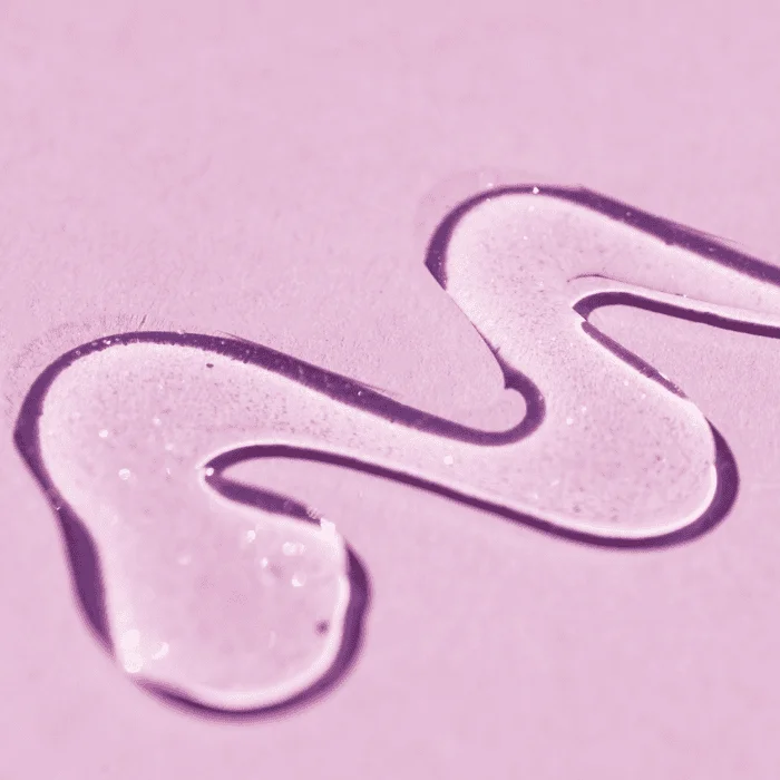 Παχύρρευστη διάφανη ουσία σε ροζ φόντο.