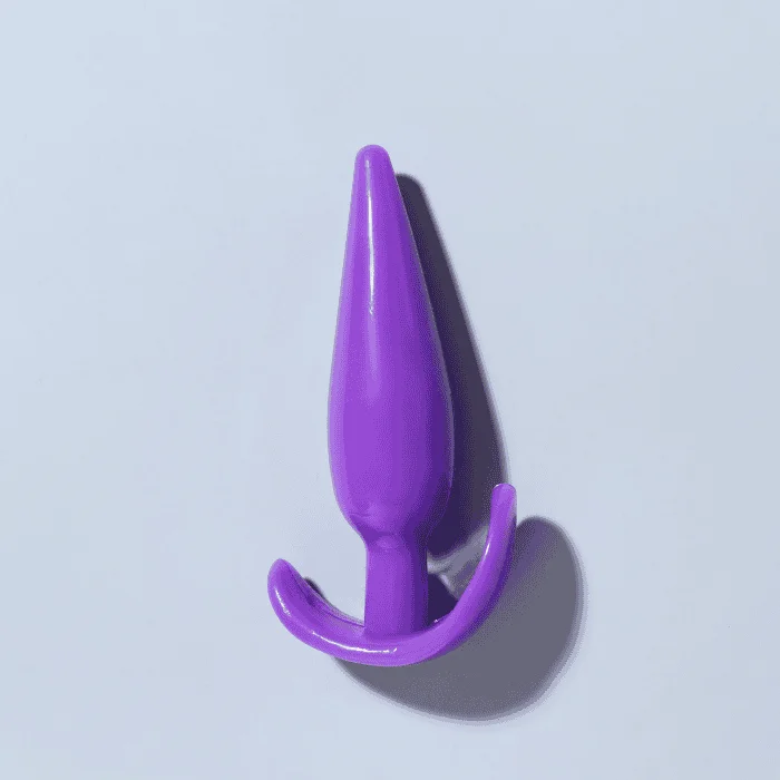 Μωβ πρωκτική σφήνα σιλικόνης με βάση τύπου άγκυρας σε ουδέτερο φόντο.